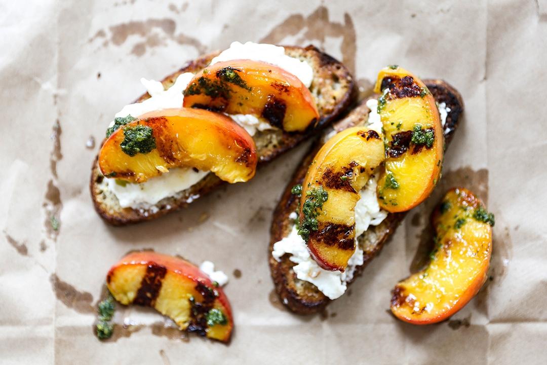 crostini appetizer with burrata, pesto, and peaches