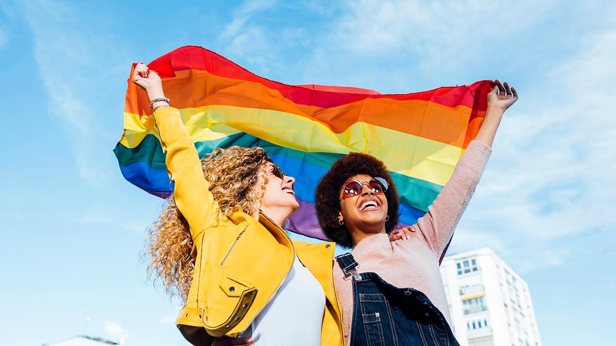 Article Cards Featured Image Two girlfriends hanging out in the city waving LGBT with pride flag