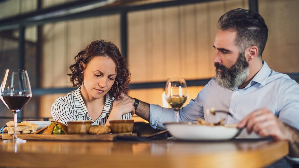 Article Cards Featured Image Adult couple is sitting at restaurant. They are having dinner wi