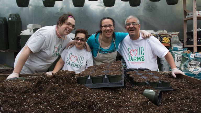 Smile farms image   group posing for photo in front of dirt