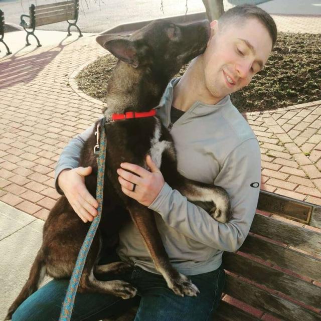 shelter animals image   dog sitting on man's lap licking his face.