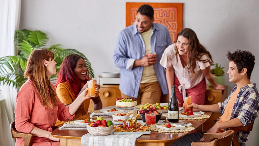 A photo of spring self care ideas with a group of friends having breakfast and laughing.