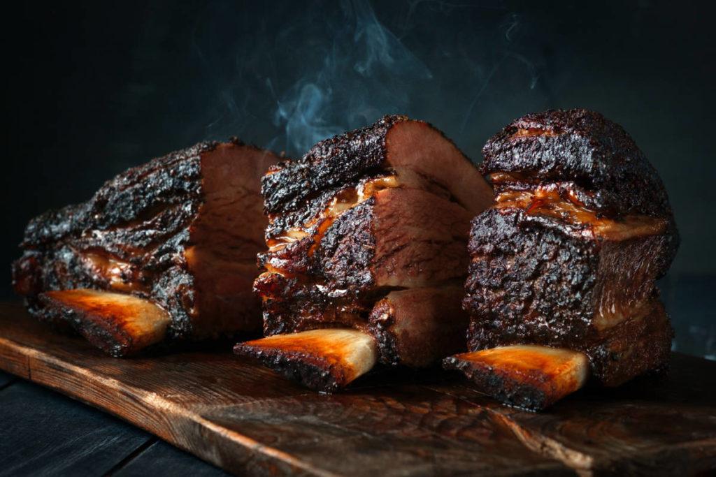 bucket list. A large steaming fragrant piece of baked beef brisket on the ribs with a dark crust. Classic Texas barbecue