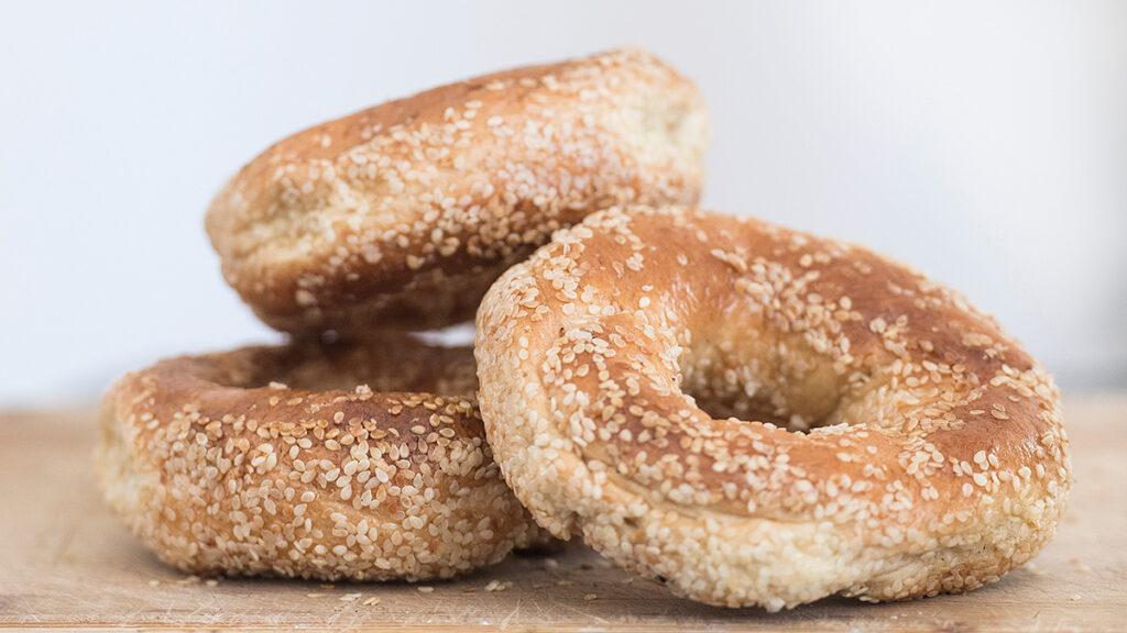 Types of bagels around the world with three Montreal bagels on a table.