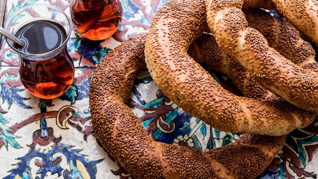 Types of bagels around the world with three sumit bagels from Turkey on a table next to glasses of tea.