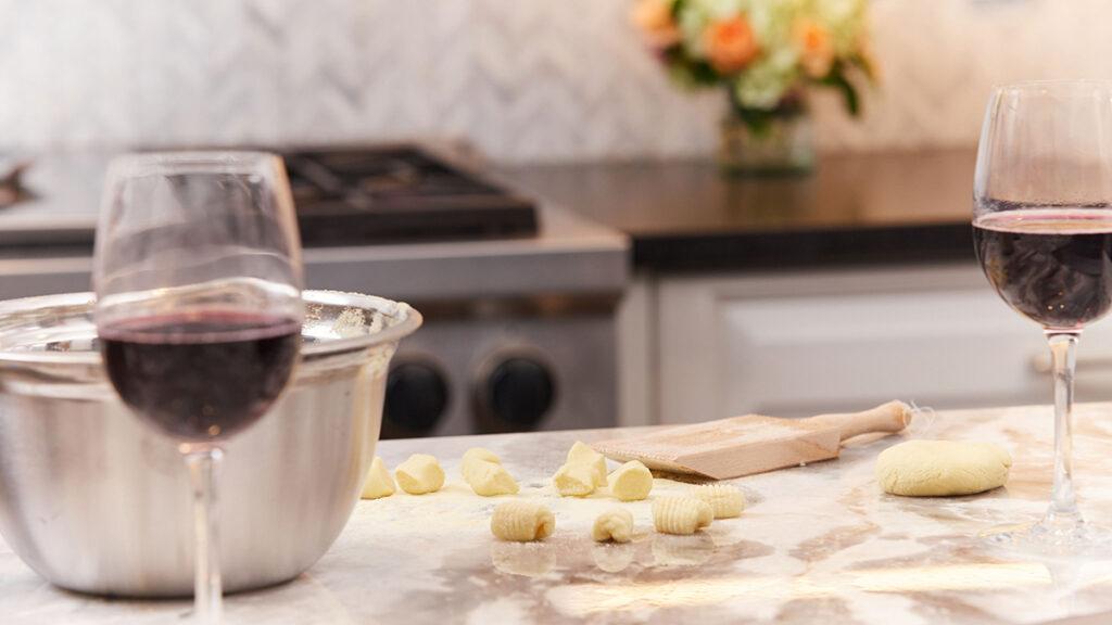 Alice's Table workshop with a counter covered in gnocchi and glasses of wine.