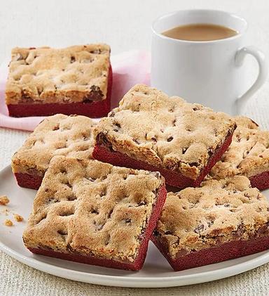 History of red velvet cake with a plate of red velvet brookies next to a cup of tea.