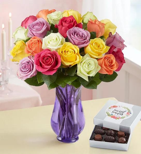 Unique thank you gifts with a bouquet of multi colored roses next to a box of chocolates.