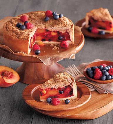 Types of peaches with a peach and berry pie on a platter.