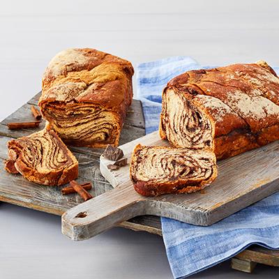 Types of pastries with two babkas on wooden boards.