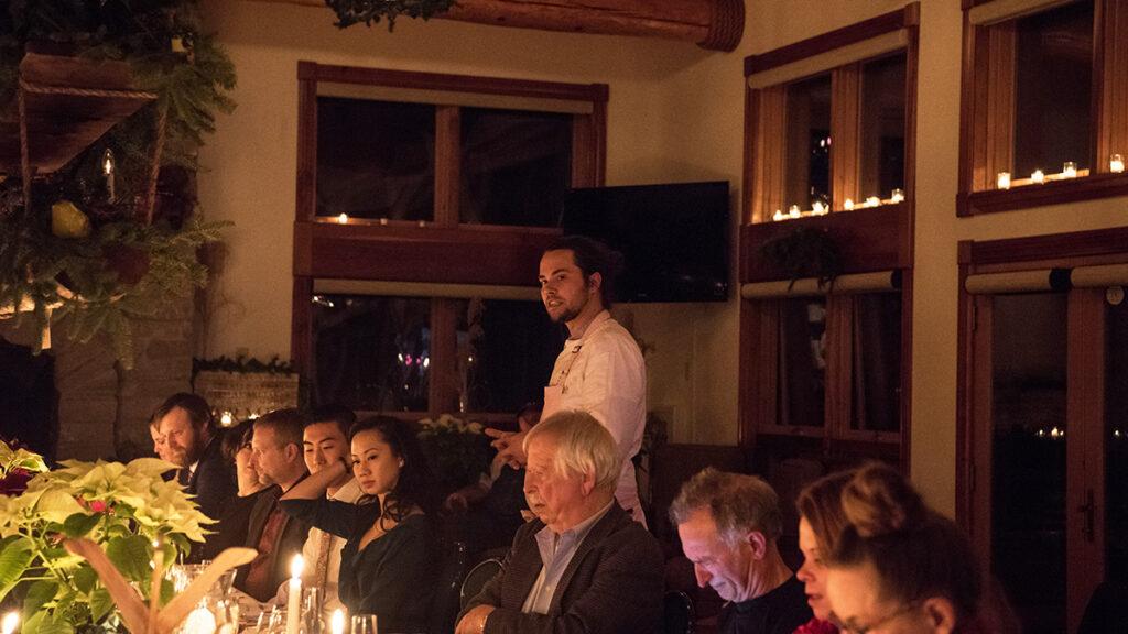 Chef Jamie Simpson talking to a table full of people about regenerative farming.