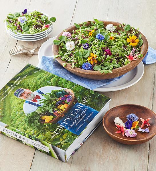 Thoughtful food gifts with a bowl of greens and flowers next to Chef's Garden cookbook.